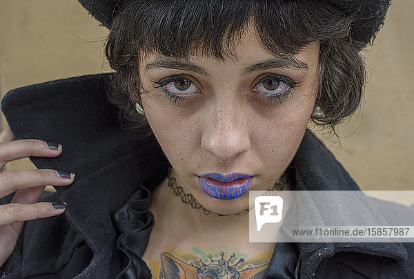 Gothic girl with blue lips and tattoed chest