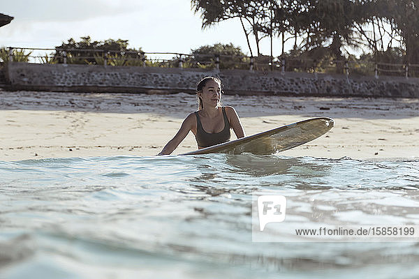 Junge Frau mit Surfbrett am Strand