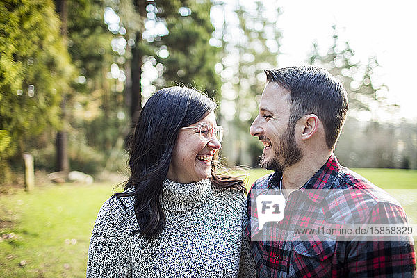 Attractive young couple sharing a laugh outdoors.
