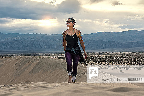 Tätowierte Frau geht auf Dünen im Death Valley