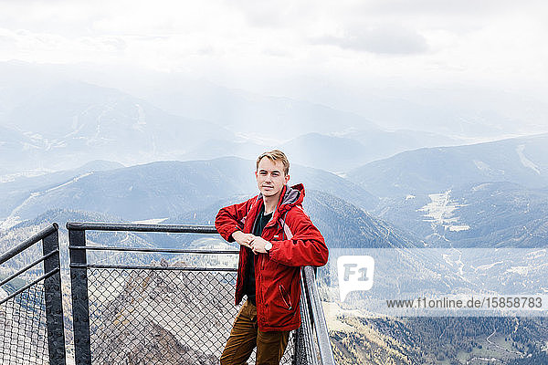 Tausendjähriger geniesst Bergblick auf die Alpen von der Aussichtsplattform
