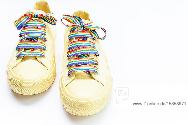 Paar gelbe Schuhe mit RegenbogenschnürsenkelnPaar gelbe Schuhe mit Regenbogen