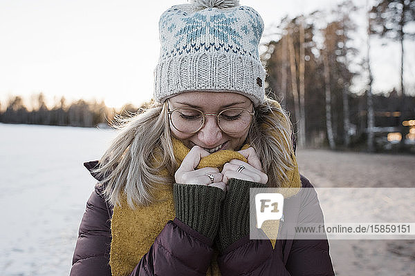 Porträt einer warm eingepackten Frau am Strand in Schweden