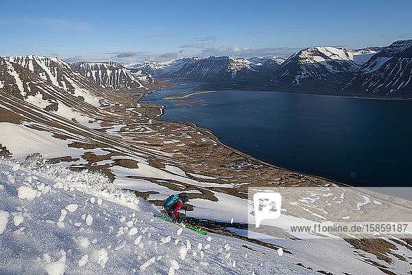 Eine Frau fährt in Island Skilanglaufski bis zum Ozean.