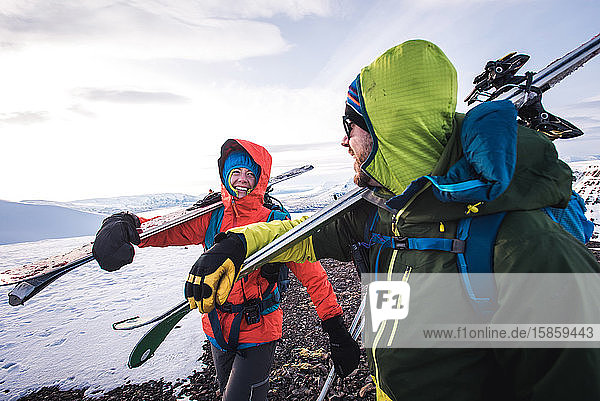Frau und Mann lachen beim Wandern mit Skiern in Island