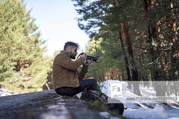 Tourist in den Bergen ruht sich mit seiner Kamera aus