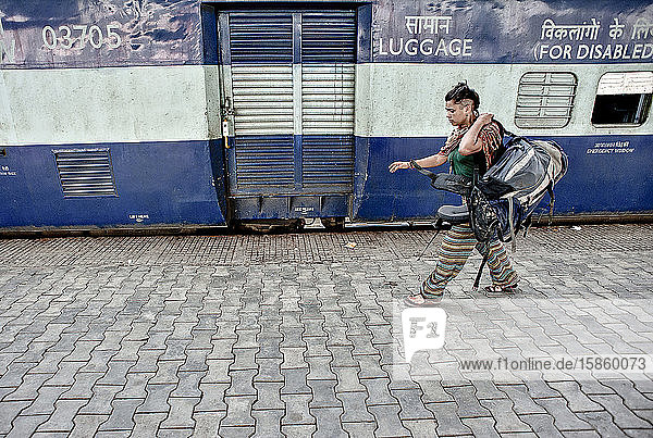 Junge Frau mit Rucksack auf dem Bahnhof in Indien
