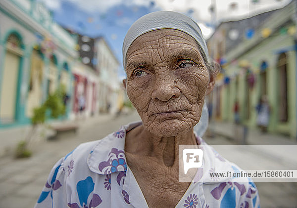 Old woman in a colorful colonial street in northeast Brazil