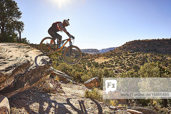 Ein Mann springt mit seinem Mountainbike auf einem Weg in Colorado.