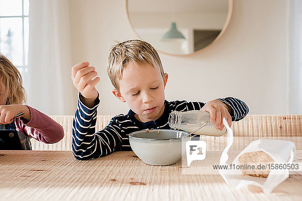 young boy during milk on his breakfast at home before school