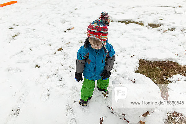 View of toddler boy from above wearing knit hat during winter weather