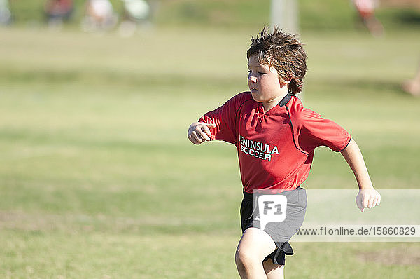 junger Fußballspieler  der während eines Spiels auf dem Spielfeld joggt