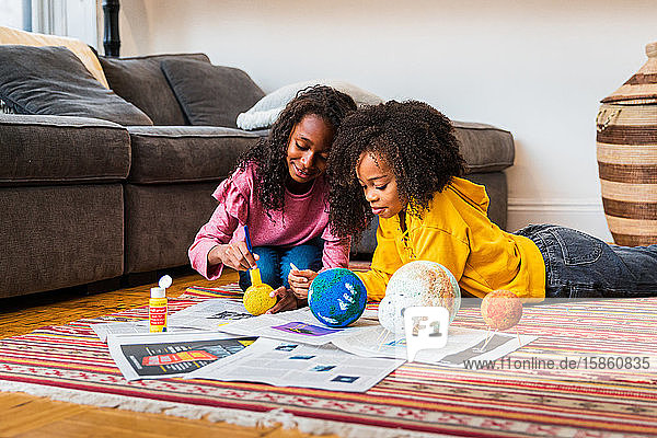 Schwestern machen Solaranlage auf Papieren im Wohnzimmer
