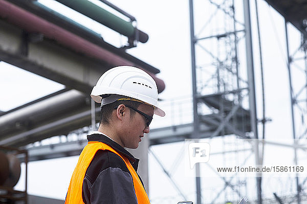 worker outside in front of pipes