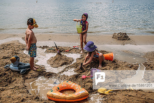 kleine Kinder  die im Sommer Sandburgen an einem Strand bauen
