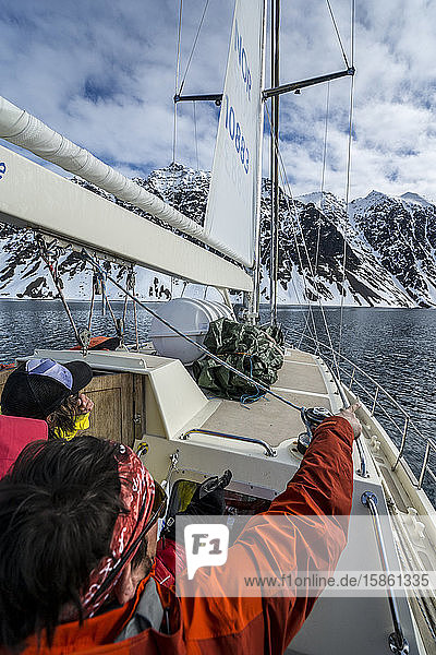 Friends on ski trip on sailboat going towards Jan Mayen