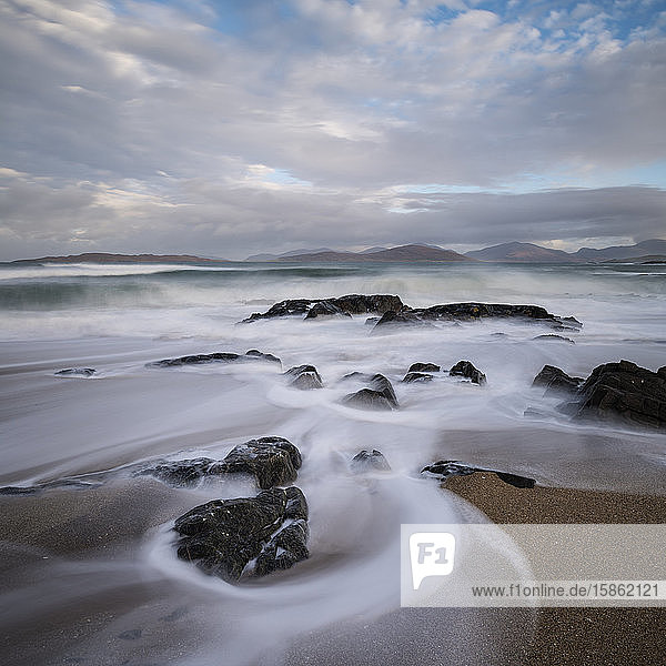 Fließende Wellen über einen kleinen felsigen Strand  nahe Scarista  Isle of Harris  Schottland