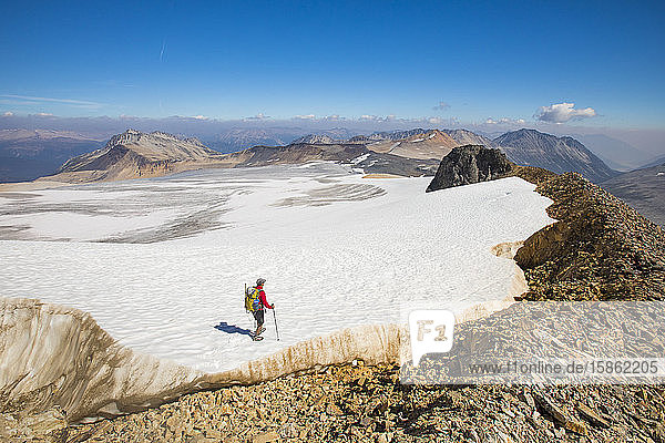 hoher Winkel eines Rucksacktouristen  der über die Spitze eines riesigen Gletschers wandert.