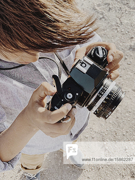 Close up portrait of a kid holding a vintage camera