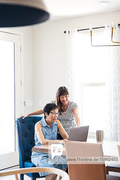 Tochter hilft Mutter mit Computer