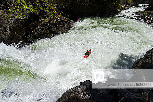 A whitewater kayaker paddles over a waterfall on the Callaghan Creek