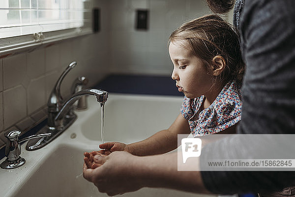 Seitenansicht eines jungen Mädchens mit vom Vater gewaschenen Händen