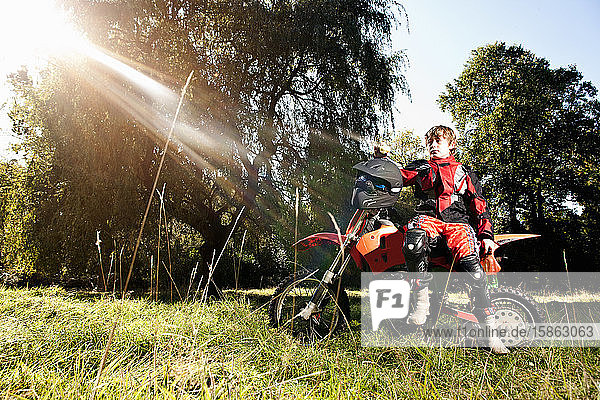 12-jähriger Junge mit einer Pause auf seinem Geländemotorrad