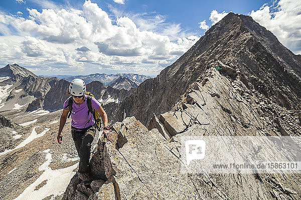Women climb narrow ridge on Capitol Peak  Elk Mountains  Colorado
