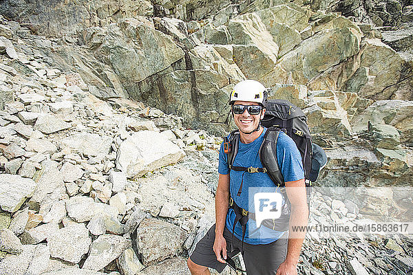 Portrait of mountaineer wearing helmet and backpack.