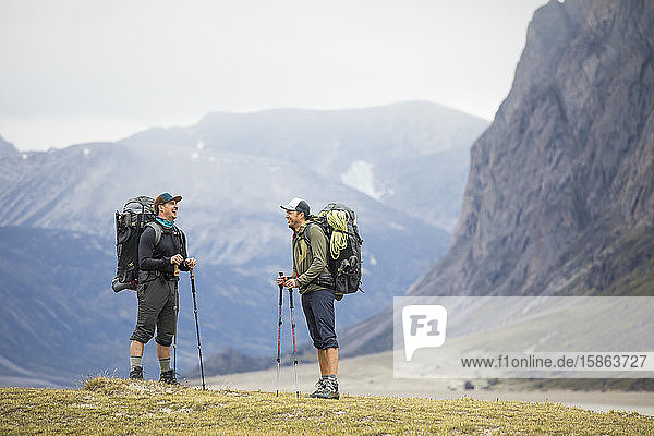 Zwei Freunde lachen beim Rucksackwandern am Akshayak-Pass
