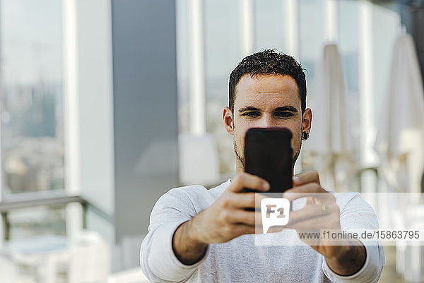 Young man taking a selfie with smartphone