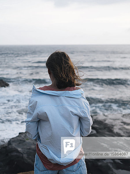 Junge Frau schaut auf den Ozean