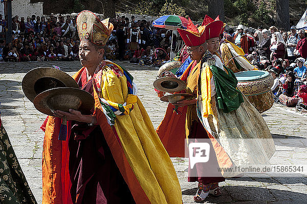 Mönchsmusiker in zeremonieller Kleidung spielen bhutanische Zimbeln und Trommeln beim Paro Tsechu (jährliches Klosterfest)  Paro  Bhutan  Asien