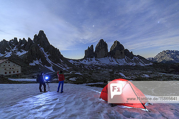 Hikers admire the Three Peaks of Lavaredo before spending the night in the tent  Sesto  Dolomites  Trentino-Alto Adige  Italy  Europe