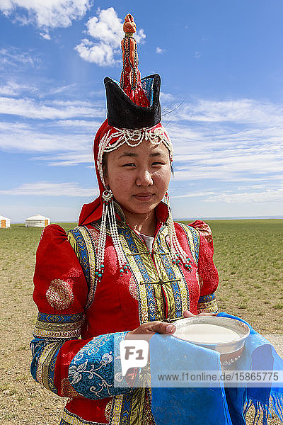 Frau mit roter Mütze und spitzem Hut und silberner Schale mit Milch zur Begrüßung von Besuchern  Wüste Gobi  bei Bulgan  Omnogov  Mongolei  Zentralasien  Asien