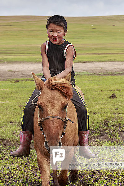 Pferd und Junge reiten ohne Sattel im Sommernomadenlager  Khujirt  Uvurkhangai (Ovorkhangai)  Zentralmongolei  Zentralasien  Asien