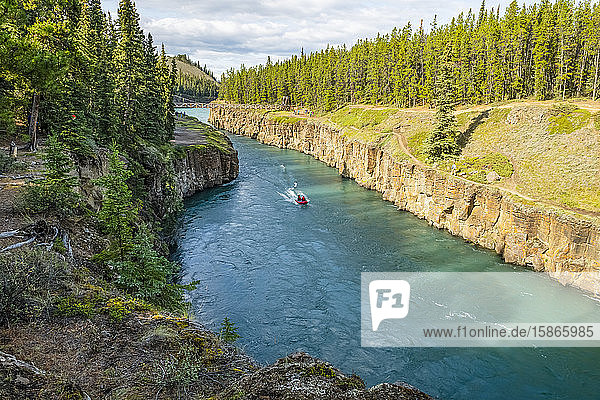 Motorboat going up the Yukon River through Miles Canyon inside the borders of Whitehorse; Whitehorse Yukon Canada