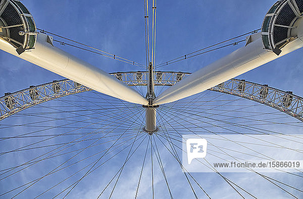 View from directly below the cables and pods of the London Eye with a blue sky in the background; London England