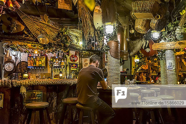 Man using his phone at Joe's Beerhouse; Windhoek Namibia