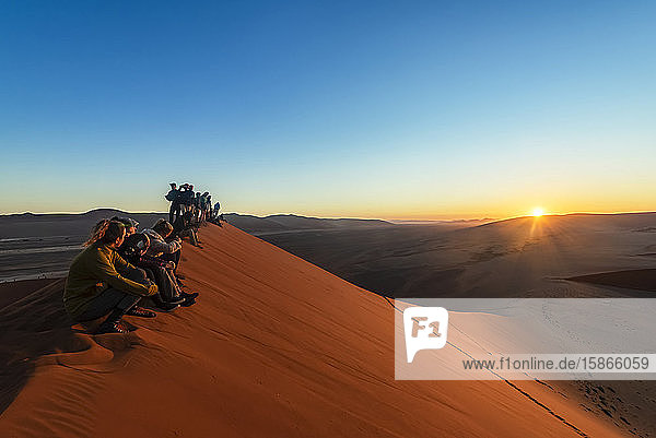 Touristen genießen den Sonnenaufgang von der Düne 45  Sossusvlei  Namib-Wüste; Namibia