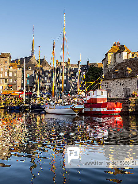 Boats reflected in the tranquil water of the harbour; Honfleur Normandy France