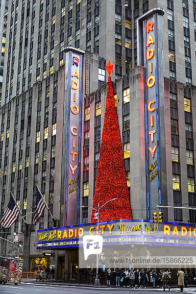 Radio City Music Hall decorated at Christmastime and tourists gathered at the corner of the intersection outside the entrance; New York City  New York  United States of America