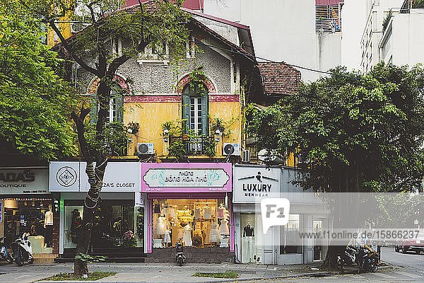 Street corner with trees and shops; Hanoi Vietnam