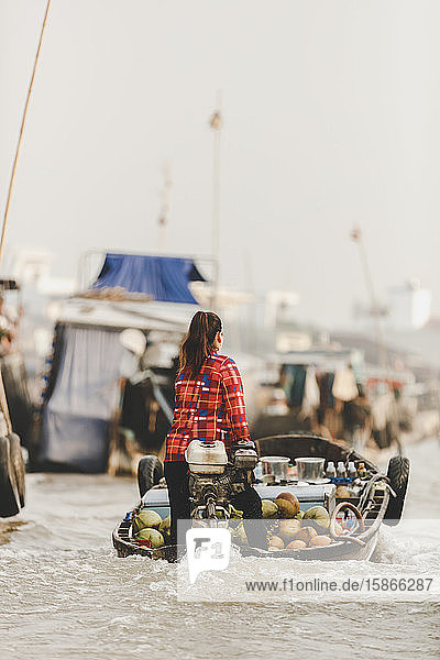 Woman transporting fresh fruit in motorboat Cai Rang Floating Market; Can Tho Vietnam