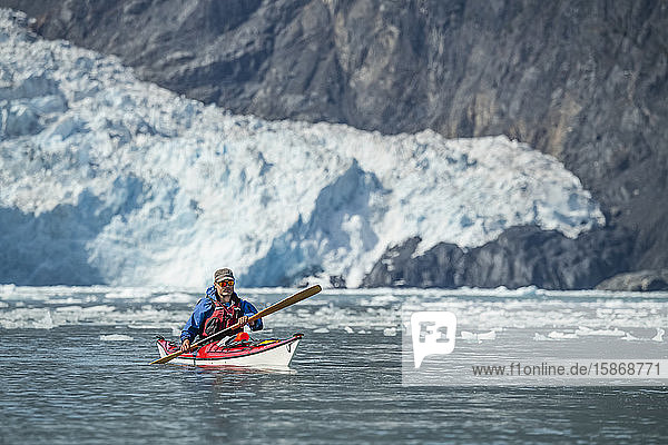 Kayaker in front of a tidewater glacier in Prince William Sound; Alaska  United States of America