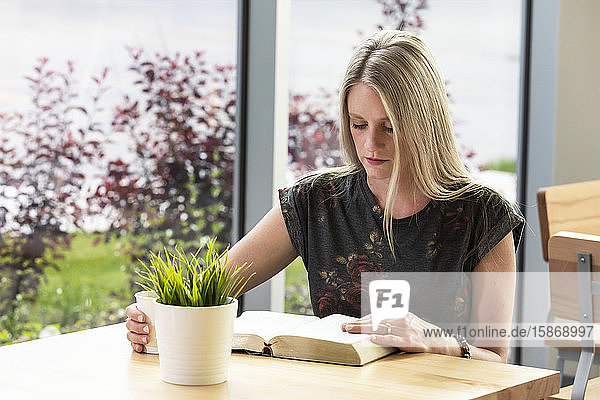 Eine reife Christin studiert ihre Bibel in einem Café: Edmonton  Alberta  Kanada