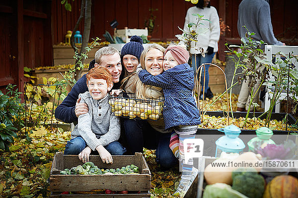 Porträt einer glücklichen Familie mit frischen Produkten im Hinterhof