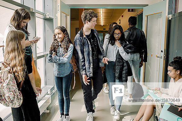 Männliche und weibliche Schüler in der Mittagspause im Schulkorridor