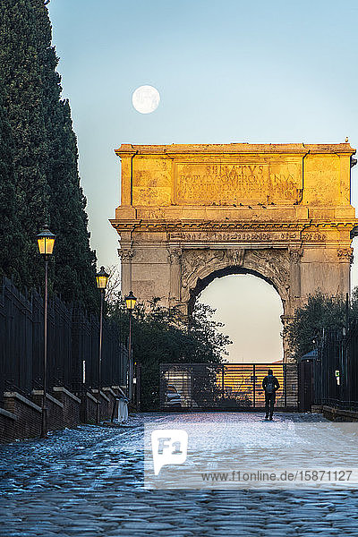 Tourist admiring the Arco di Tito triumphal arch Imperial Forum UNESCO World Heritage Site Rome Lazio Italy Europe