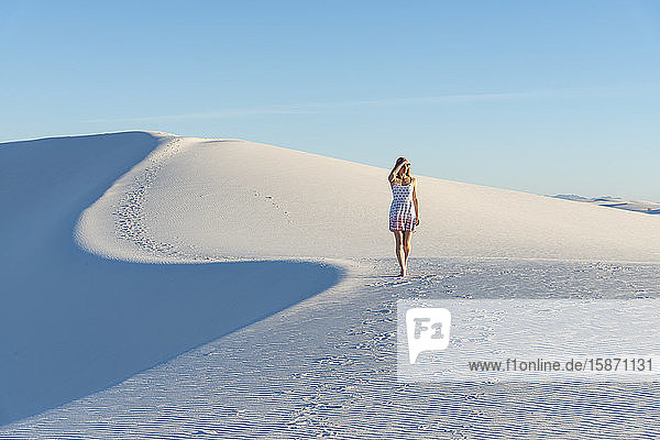 Eine Frau geht entlang der S-Kurve eines Dünenkamms im White Sands National Park  New Mexico  Vereinigte Staaten von Amerika  Nordamerika